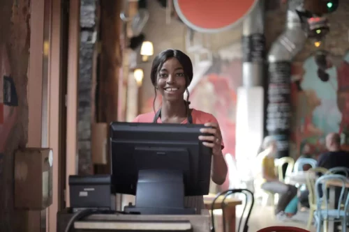 Smiling customer-service professional standing behind a counter